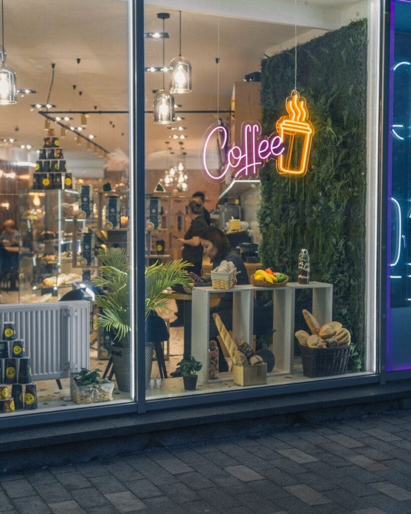 a coffee shop with a neon sign in the window